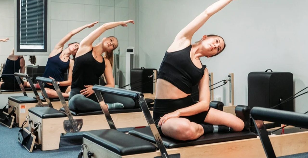 Instructor guiding a client on the reformer